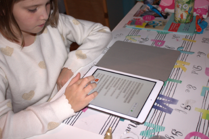 Une enfant utilisant la plateforme de lecture adaptée SONDO sur tablette