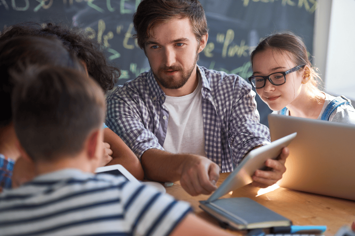 Un enseignant montre une ressource sur une tablette à des élèves